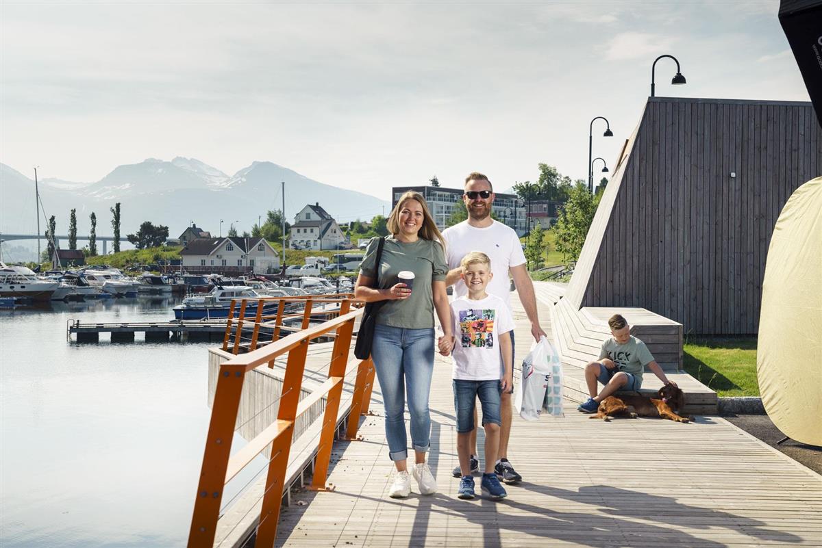Bilete som visar ein familie på sjøfronten i Vestnes sentrum med handleposar - Klikk for stort bilete