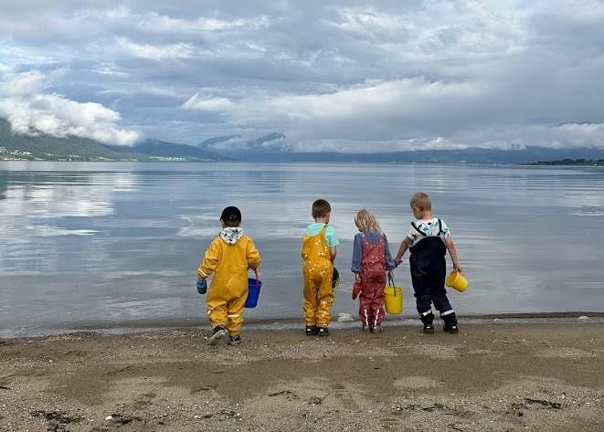Bilete som viser barnehagebarn i leik i fjøra. - Klikk for stort bilete