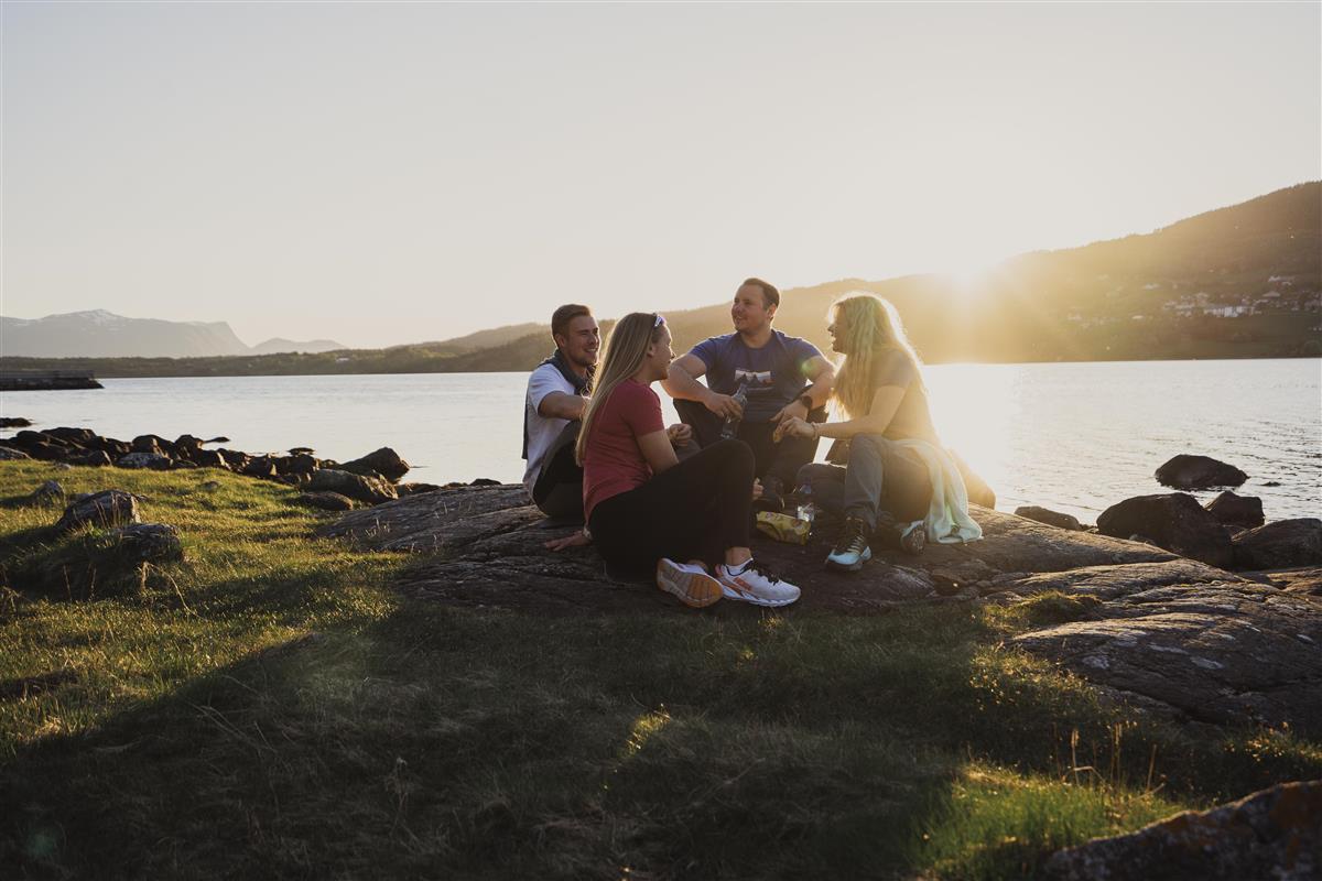 Folk som sit saman i kveldssola - Klikk for stort bilete